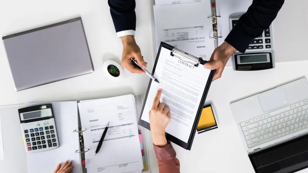 Two people reviewing a contract, emphasizing the importance of protecting designs and intellectual property in manufacturing.